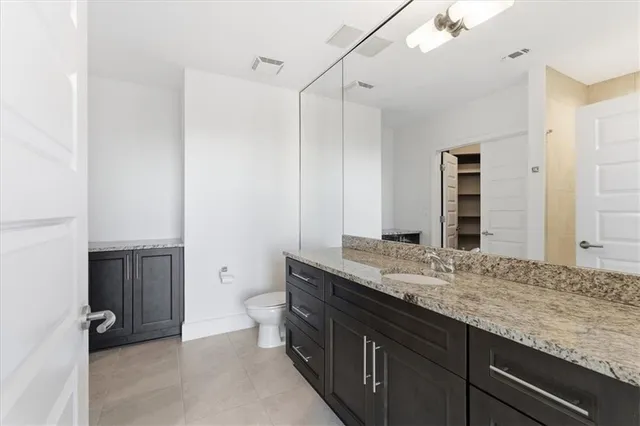 a bathroom with a granite countertop sink a toilet and shower