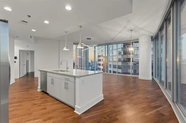 a large white kitchen with large window and stainless steel appliances