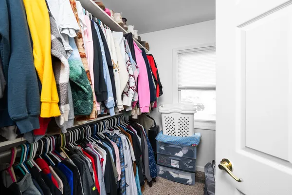 a view of walk in closet with clothes and shoes