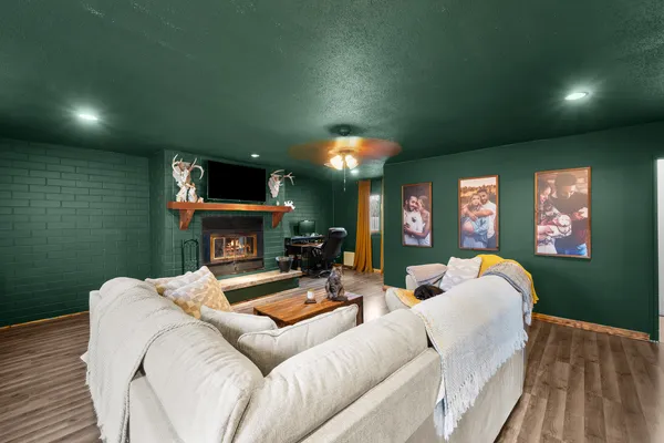 a living room with furniture a fireplace and a wooden floor