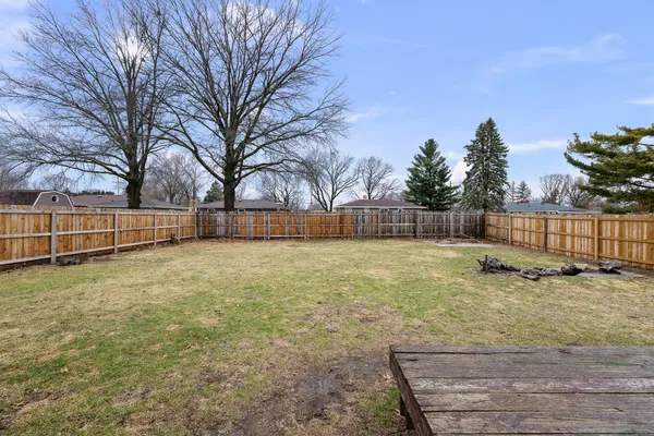 a view of backyard with wooden fence