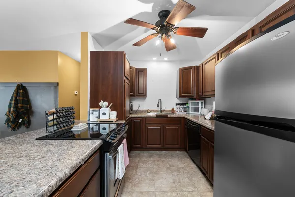 a kitchen with stainless steel appliances granite countertop sink stove and refrigerator