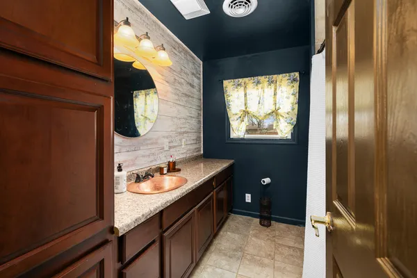 a bathroom with a granite countertop sink and a mirror