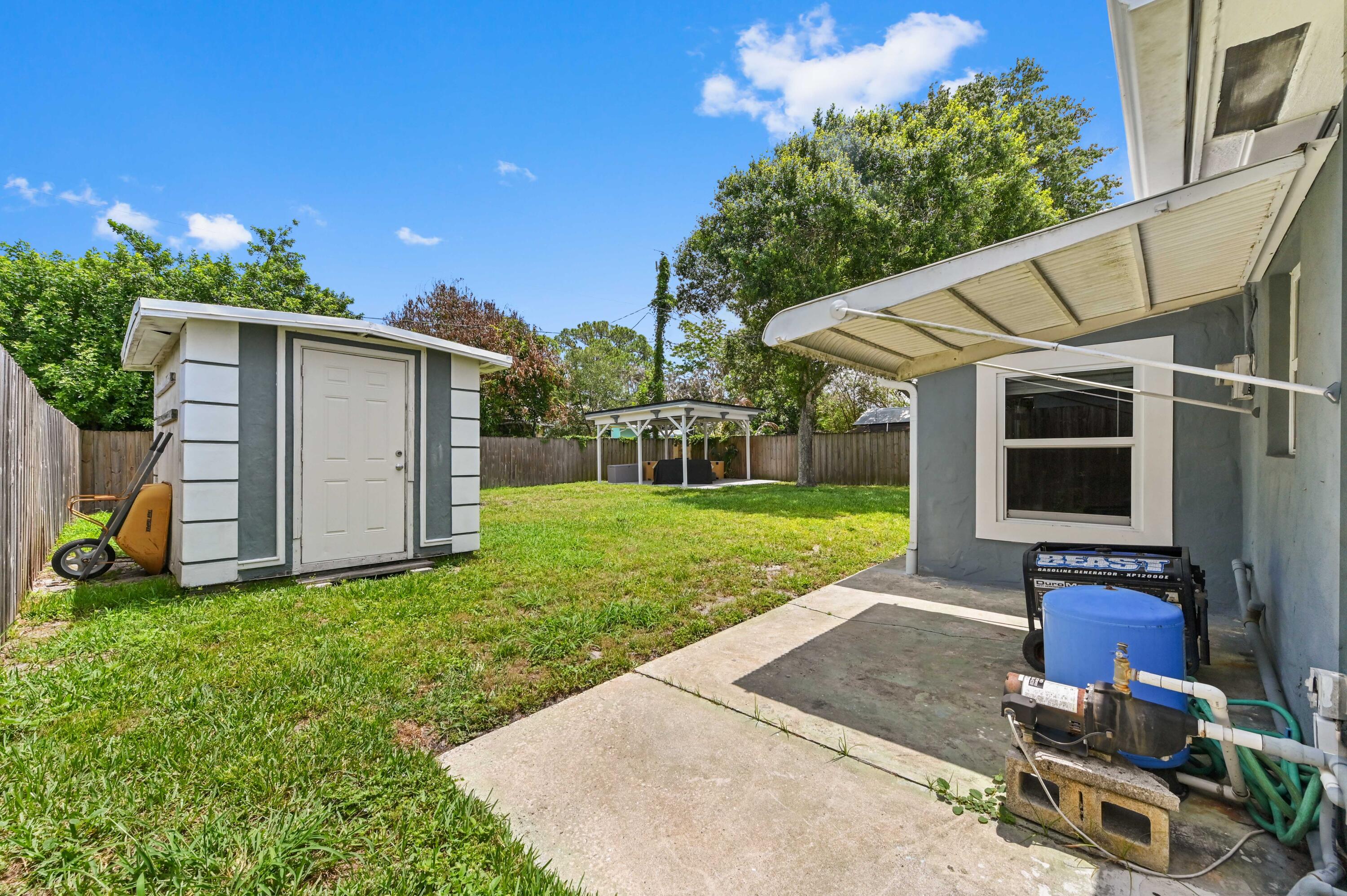 5709 Southeast Indigo Avenue Stuart, FL 34997 - Photo 25 of 26 a view of a backyard with plants and a patio