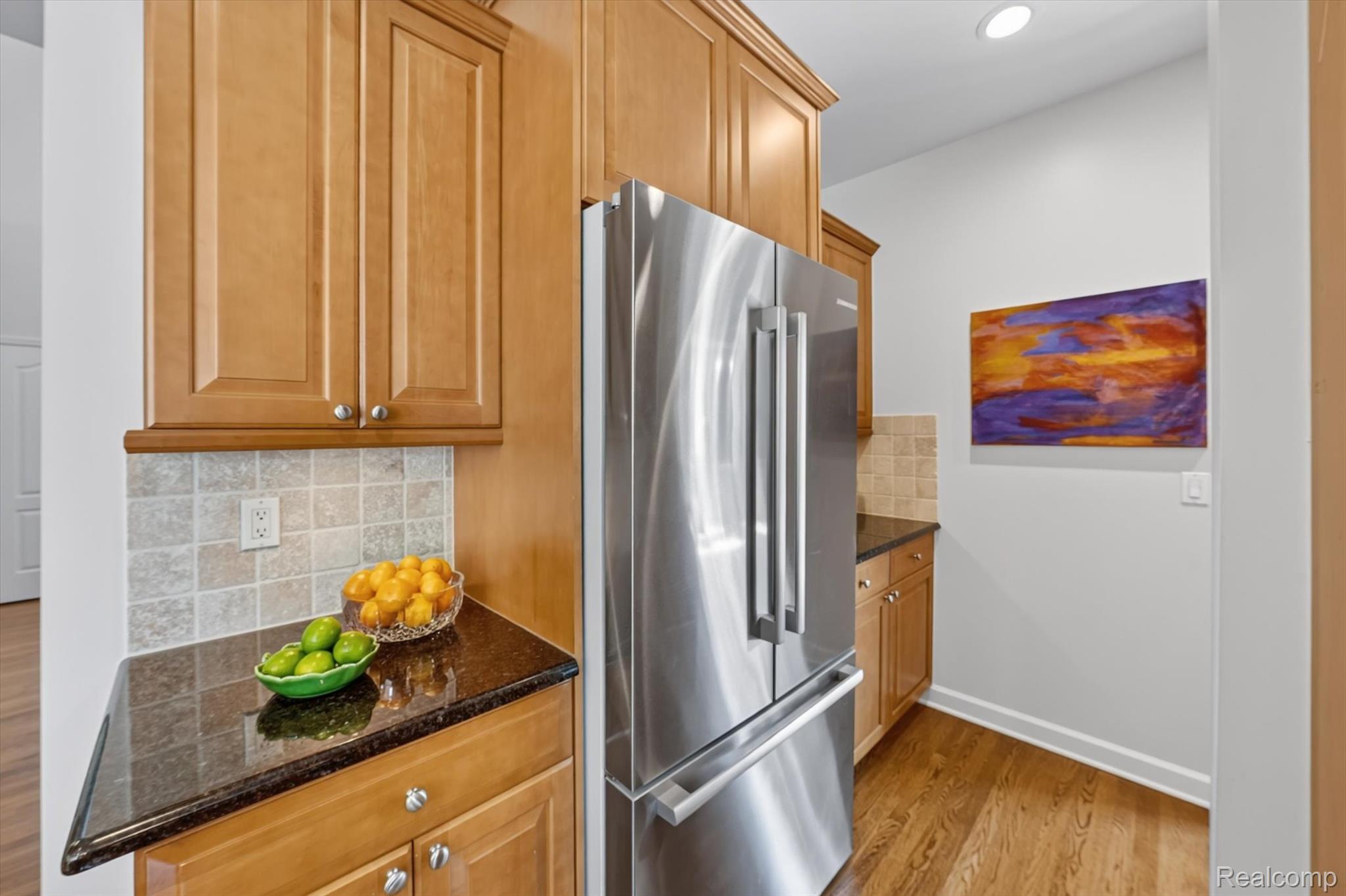 3804 Elk Drive Rochester, MI 48306 - Photo 27 of 75 Stainless steel French door refrigerator set against a tiled backsplash and dark countertop