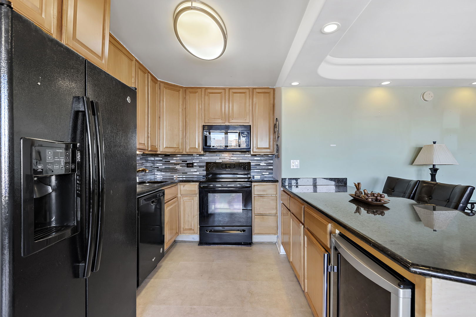 655 West Irving Park Road, Unit 1806 Chicago, IL 60613 - Photo 9 of 35 a kitchen with stainless steel appliances granite countertop a refrigerator a stove a sink and a microwave