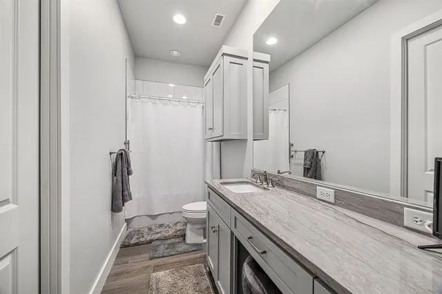 a bathroom with a double vanity sink a toilet and a mirror