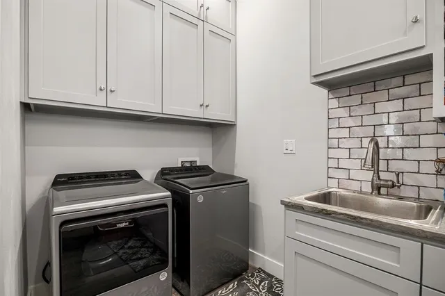 a kitchen with granite countertop white cabinets and a stove top oven