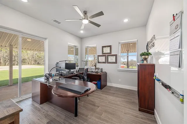 a living room with furniture a large window wooden floor and a rug
