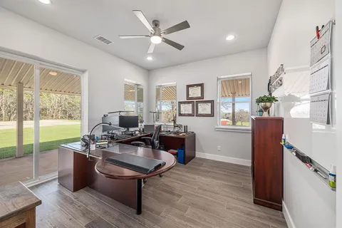 a living room with furniture a large window wooden floor and a rug