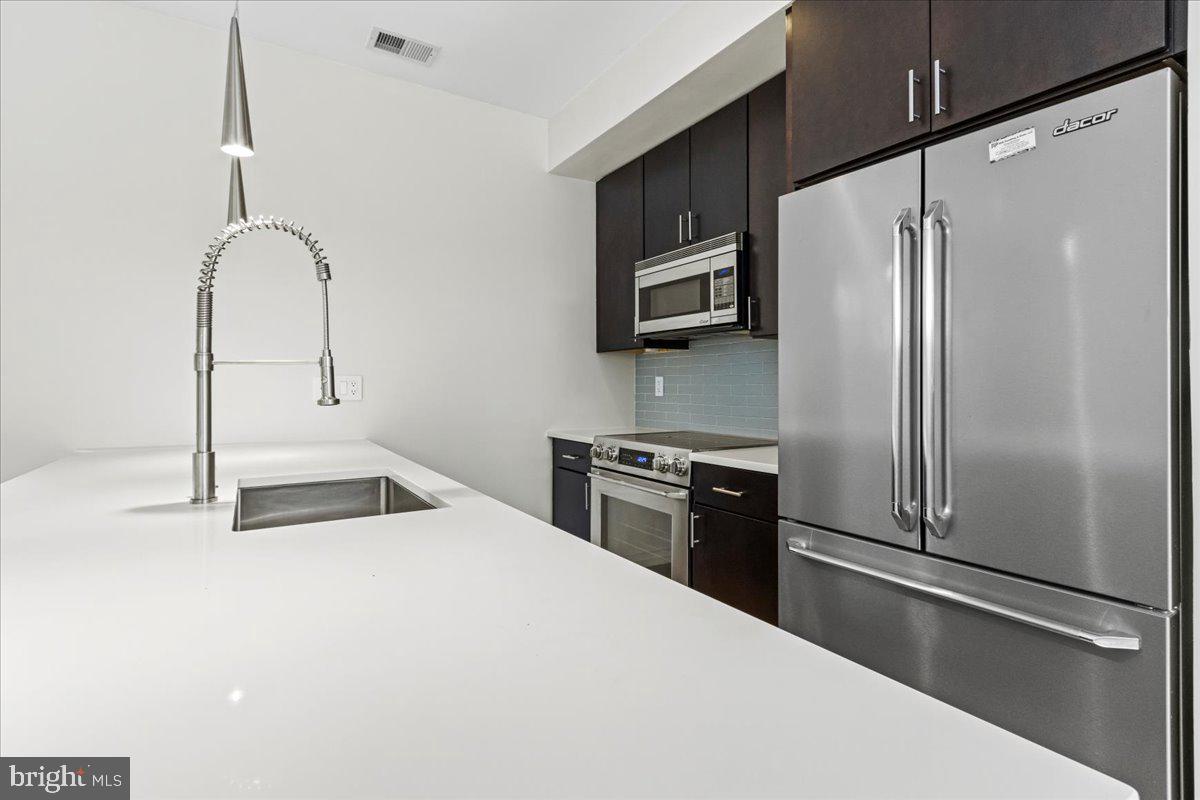 1032 Otis Street Northeast, Unit G01 Washington, DC 20017 - Photo 6 of 12 a kitchen with stainless steel appliances a refrigerator sink and stove