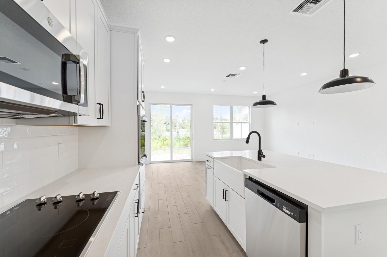 188 Southeast Birch Terrace, Unit 313 Stuart, FL 34997 - Photo 9 of 30 a kitchen with stainless steel appliances granite countertop a sink a stove and a wooden floors
