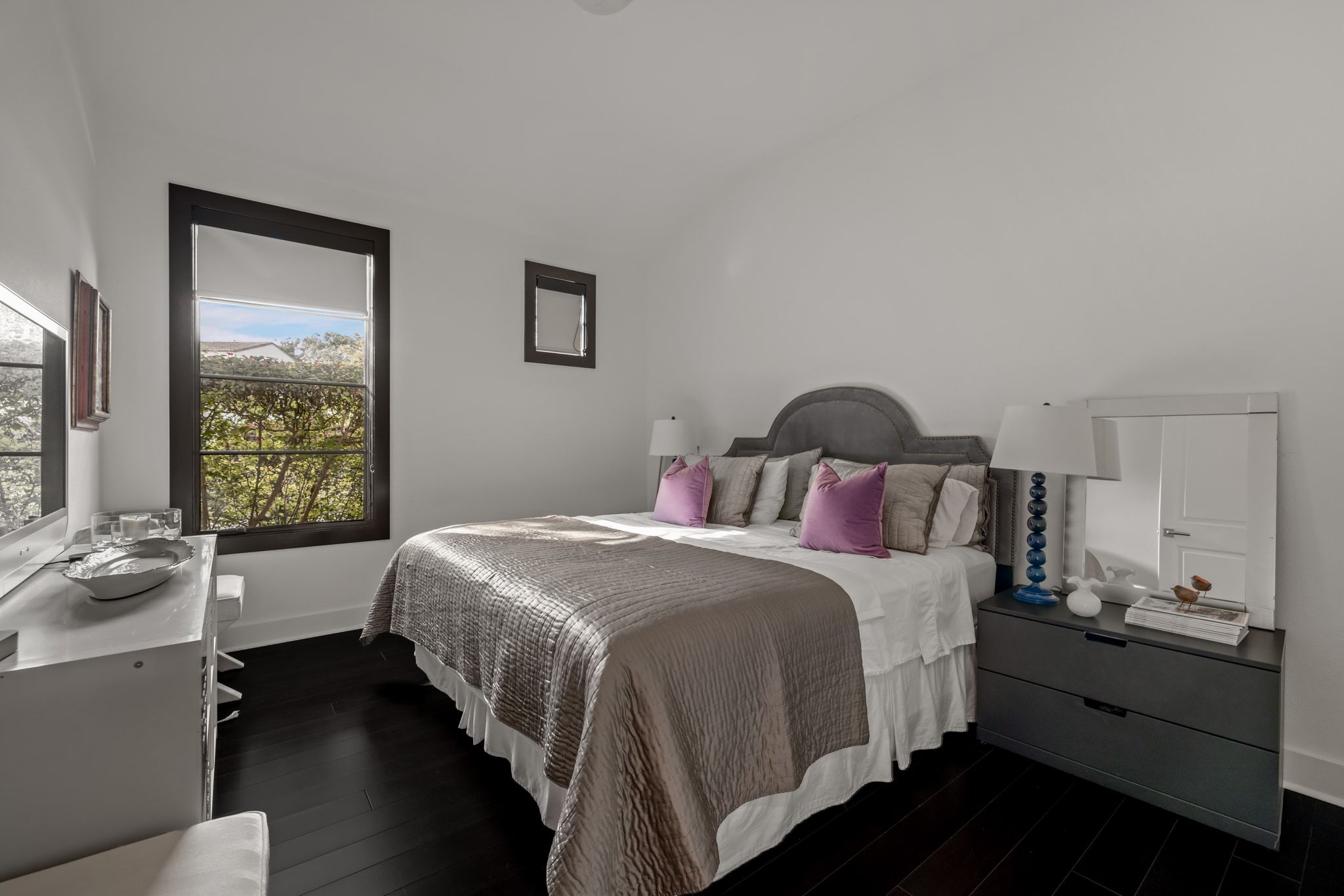 4720 Rockcliff Road, Unit 1 Austin, TX 78746 - Photo 28 of 39 Rich hardwood flooring complements a bedroom with a tranquil window view of lush greenery.