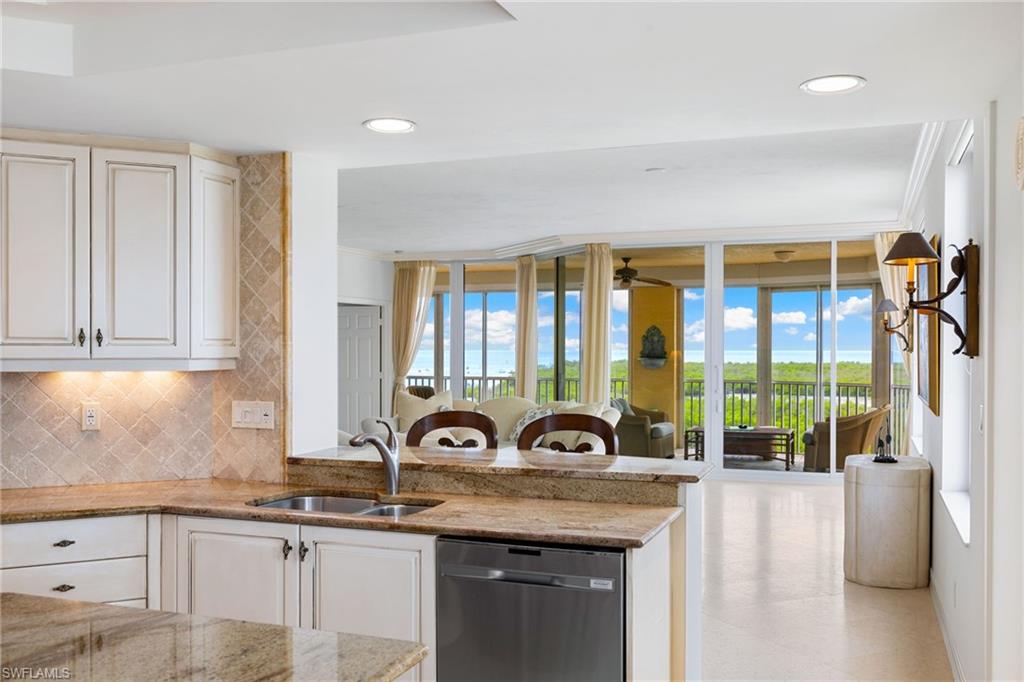 435 Dockside Drive, Unit A804 Naples, FL 34110 - Photo 50 of 50 Kitchen featuring backsplash, dishwasher, open floor plan, light stone countertops, and a peninsula