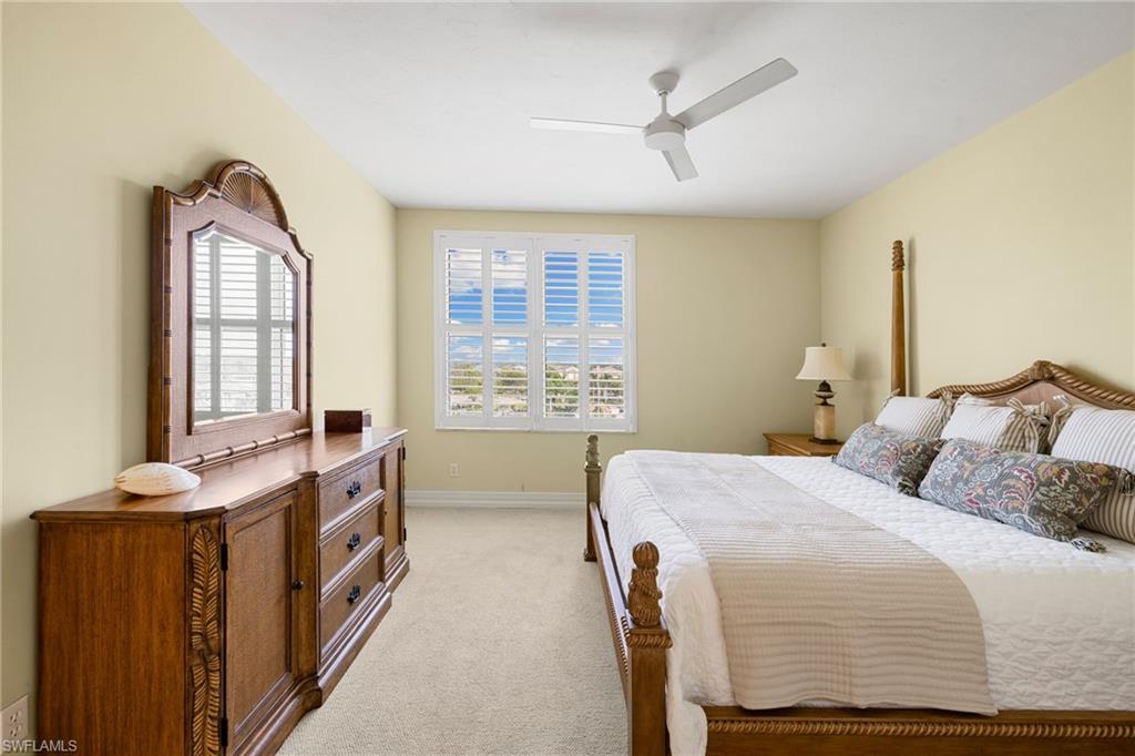 435 Dockside Drive, Unit A804 Naples, FL 34110 - Photo 28 of 50 Bedroom with multiple windows, light colored carpet, and a ceiling fan