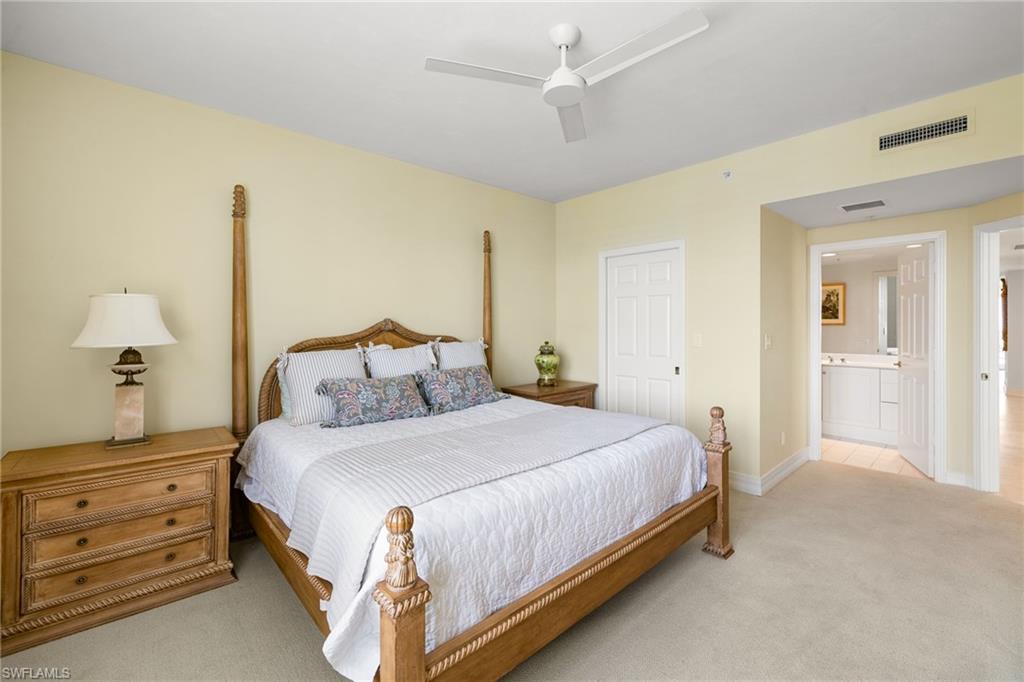 435 Dockside Drive, Unit A804 Naples, FL 34110 - Photo 29 of 50 Bedroom with light colored carpet, a ceiling fan, and ensuite bathroom