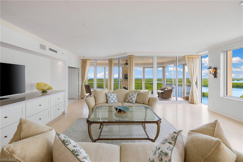 435 Dockside Drive, Unit A804 Naples, FL 34110 - Photo 9 of 50 Living area with a wall of windows, crown molding, a water view, and ceiling fan