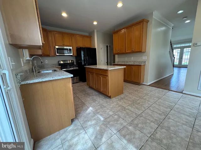 a kitchen with stainless steel appliances granite countertop a refrigerator stove microwave and sink