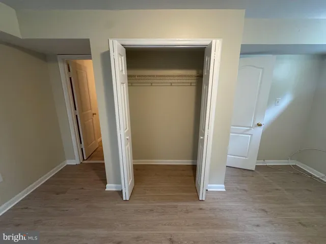 an empty room with wooden floor and closet
