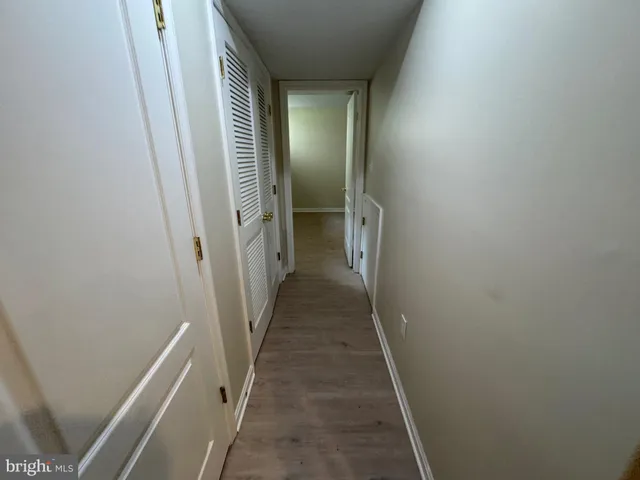 an empty room with wooden floor and entryway