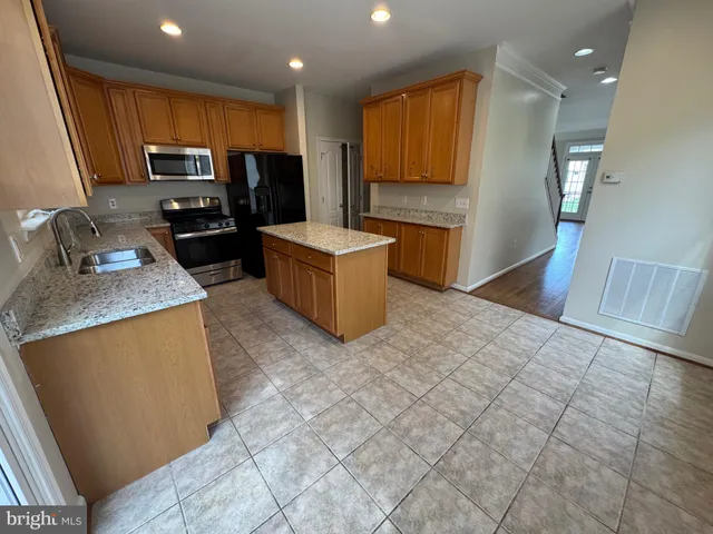 a kitchen with stainless steel appliances granite countertop a stove top oven a sink a counter top space and cabinets