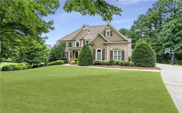 a front view of a house with a garden and trees