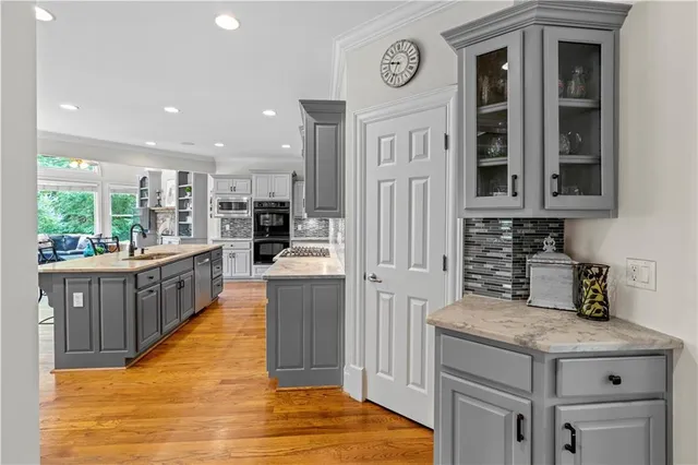 a kitchen with kitchen island granite countertop a table chairs sink and cabinets