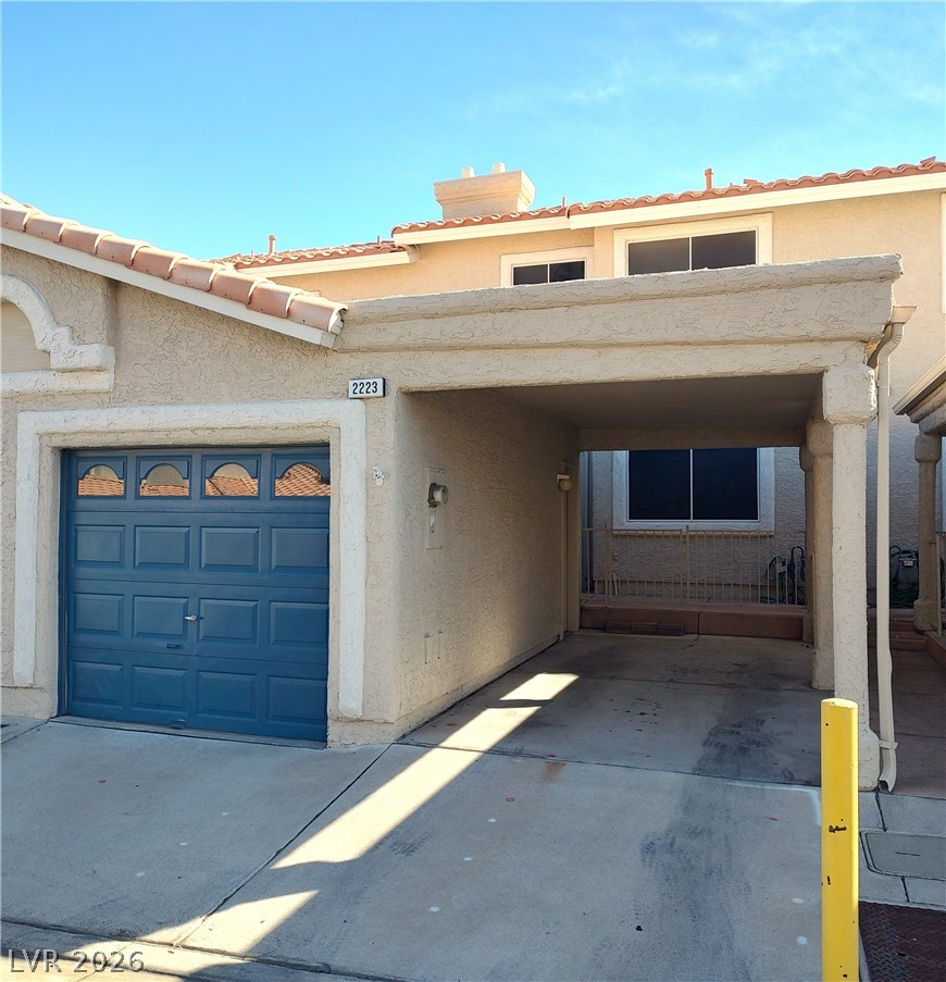2223 Rugged Mesa Drive Laughlin, NV 89029 - Photo 33 of 39 Doorway to property featuring driveway, an attached garage, a tile roof, and stucco siding