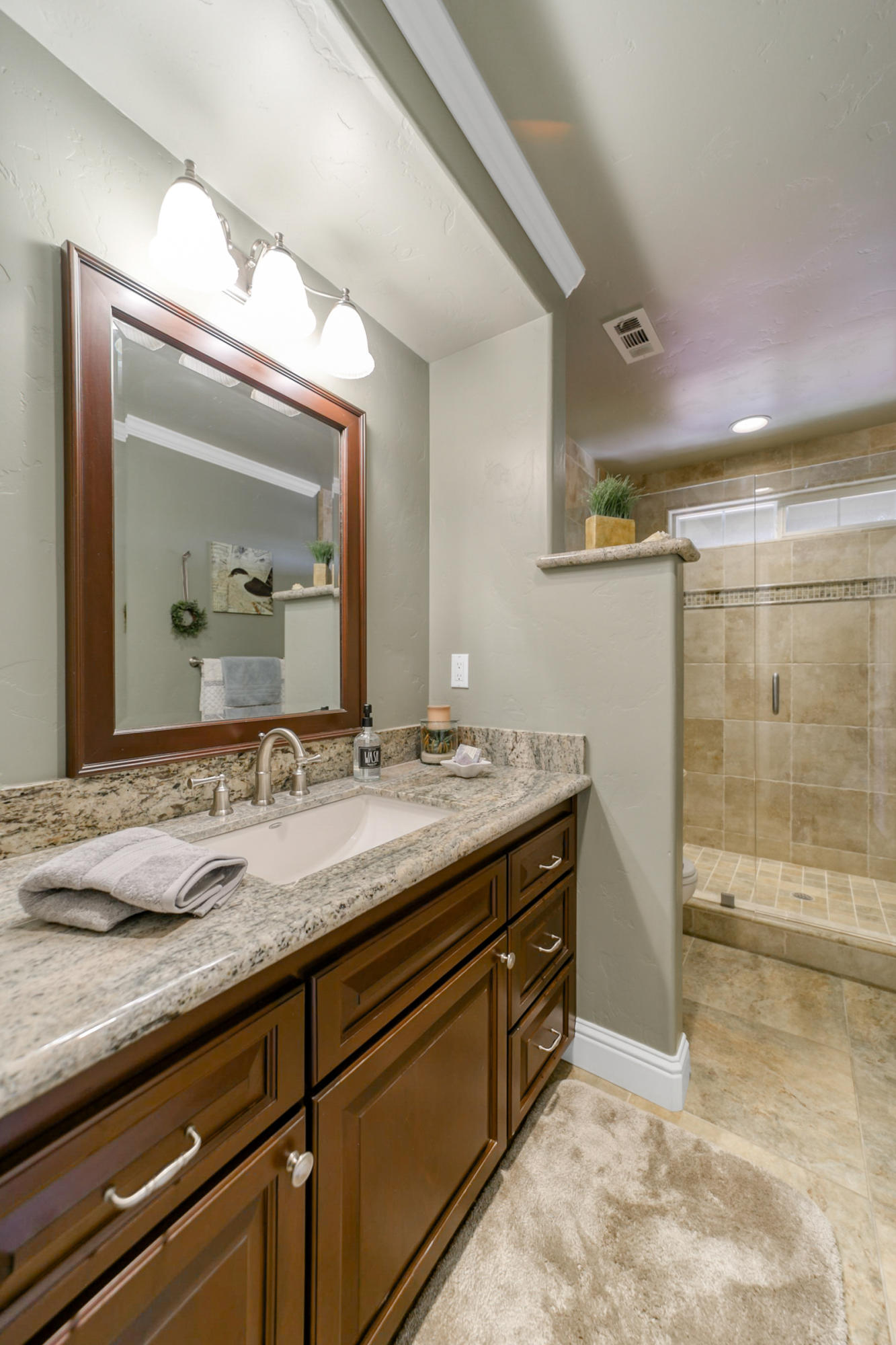 14385 Del Oro Court Red Bluff, CA 96080 - Photo 18 of 33 a bathroom with a granite countertop sink a mirror and a shower