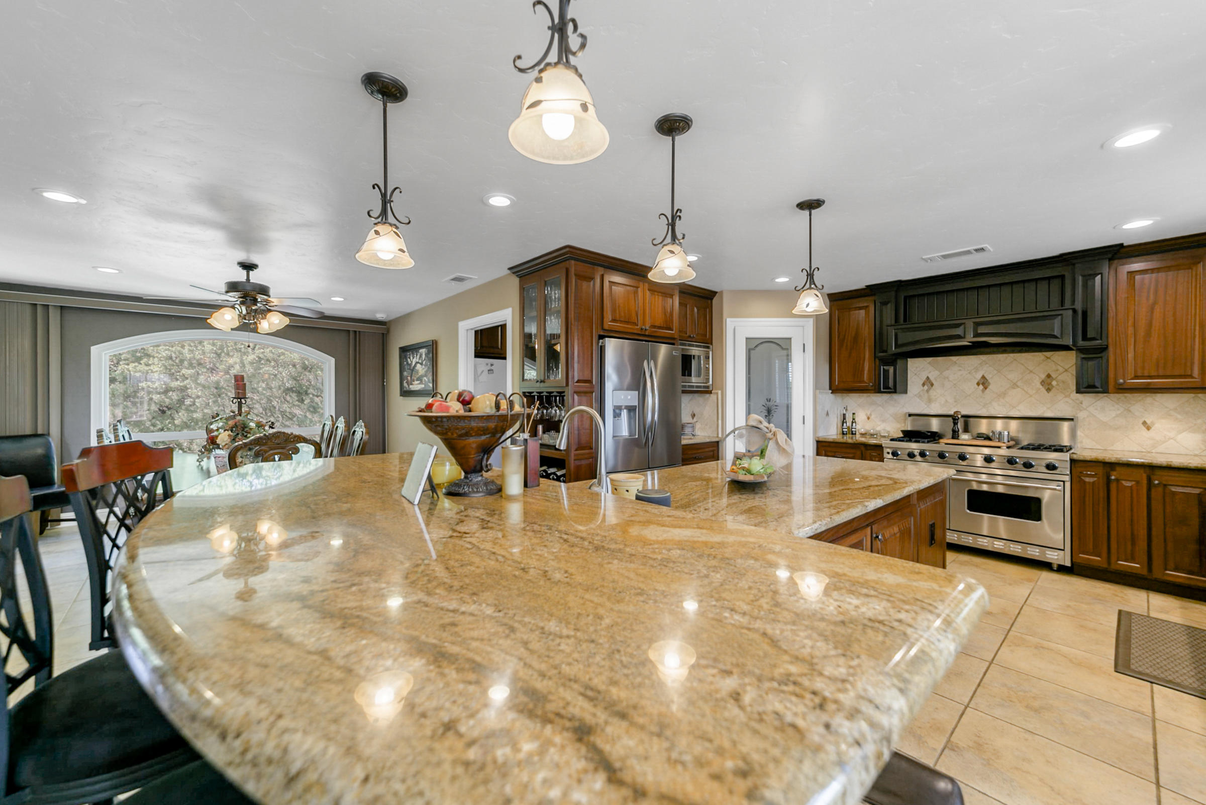 14385 Del Oro Court Red Bluff, CA 96080 - Photo 4 of 33 a large kitchen with stainless steel appliances granite countertop a stove a sink a oven a dining table and chairs with the view of kitchen