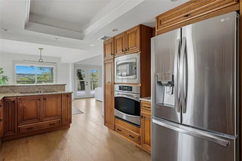 a kitchen with stainless steel appliances granite countertop a refrigerator and a stove top oven