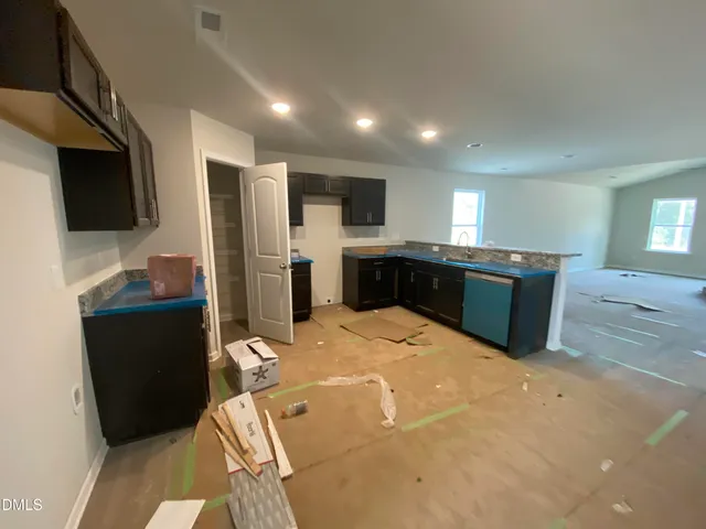 a kitchen with stainless steel appliances kitchen island granite countertop a refrigerator a sink a stove with wooden cabinets