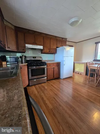 a kitchen with granite countertop wooden floors and stainless steel appliances