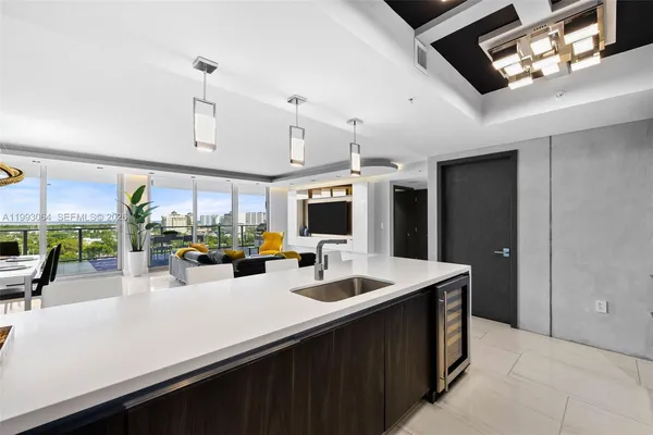 a kitchen with stainless steel appliances kitchen island granite countertop a sink counter space and living room view