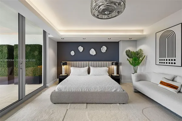 a bedroom with a large bed and a chandelier