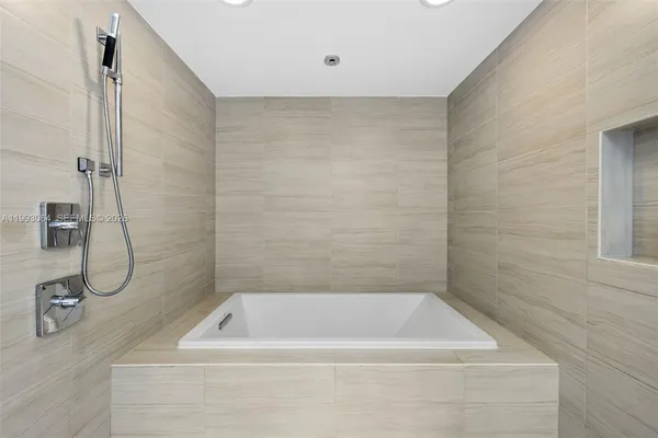 a bedroom with a large bed and a night stand