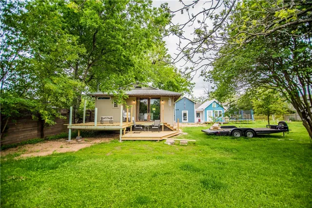 a front view of a house with a garden and trees