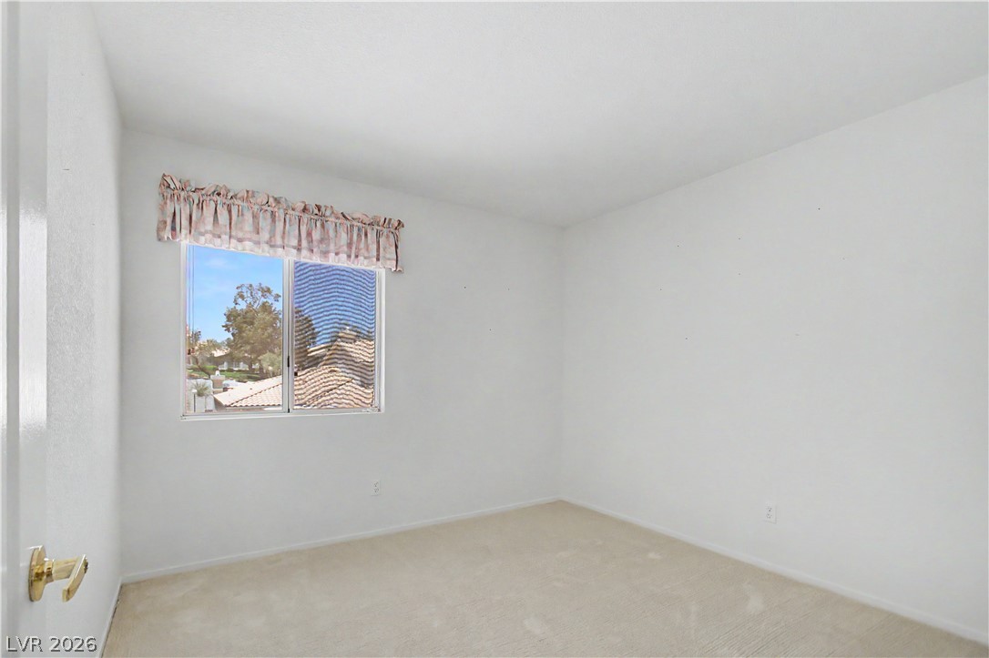2243 Rugged Mesa Drive Laughlin, NV 89029 - Photo 25 of 32 A well-lit bedroom with soft carpeting and an inviting window offers peaceful repose.