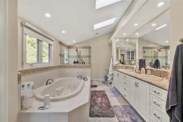 a large bathroom with a tub a double vanity sink and mirror