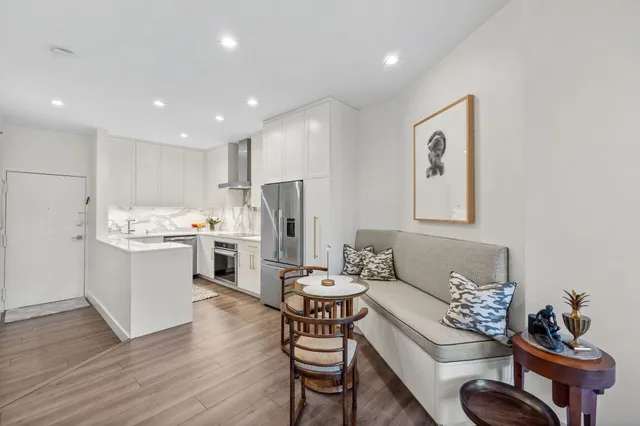 a living room with kitchen island furniture and a refrigerator