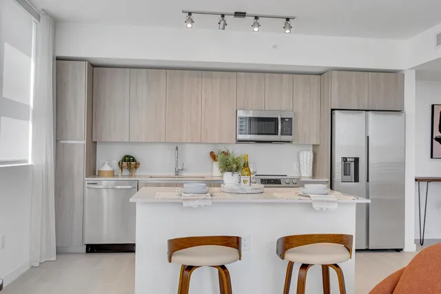 a kitchen with stainless steel appliances granite countertop a white cabinets and a stove top oven