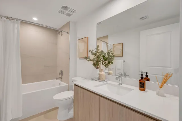 a bathroom with a granite countertop sink a toilet and shower