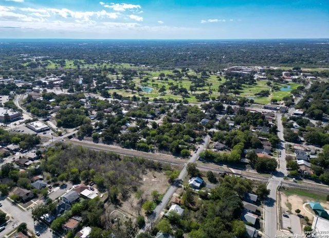 an aerial view of residential houses with outdoor space and trees