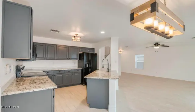 a large kitchen with kitchen island a sink stainless steel appliances and cabinets