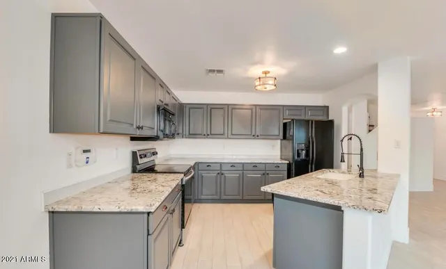 a kitchen with stainless steel appliances granite countertop a sink refrigerator and cabinets