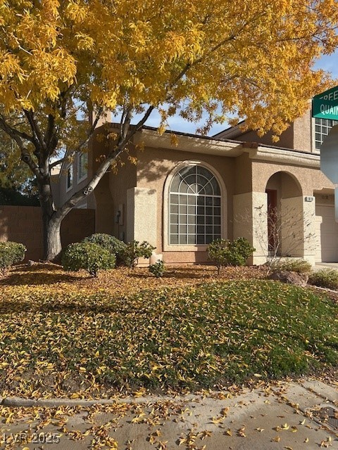 View of property exterior with stucco siding and a garage
