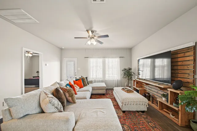 a living room with furniture flat screen tv and a window