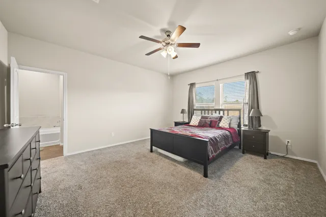 a spacious bedroom with a bed and a chandelier