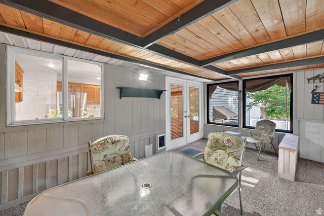 1464 990 West Provo, UT 84601 - Photo 36 of 41 Enclosed porch featuring a wood-panel ceiling with exposed beams, light gray vertical paneling, and a full-light French door entry