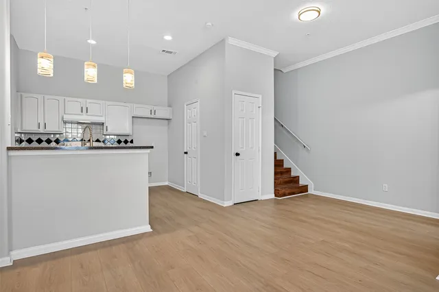 a kitchen with a sink cabinets and wooden floor